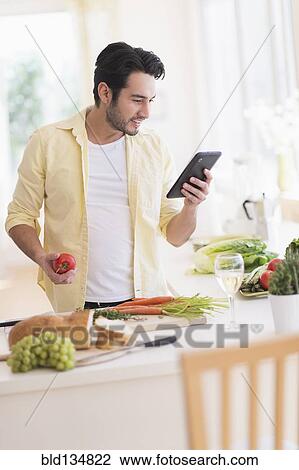 Mixed race man cooking with digital tablet in kitchen View Large Photo Image Stock Image - Mixed race man cooking with digital tablet in kitchen. Fotosearch