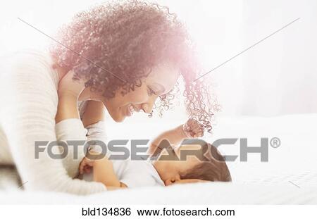 Stock Photograph - Mixed race mother admiring baby. Fotosearch