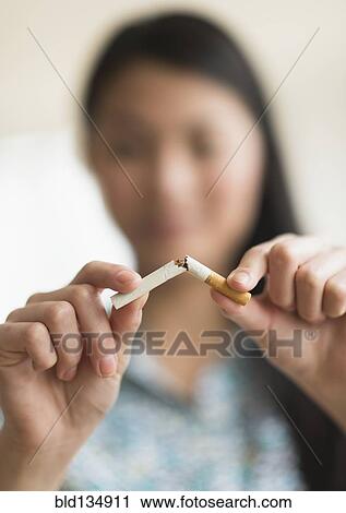 Mixed race teenage girl breaking cigarette in half View Large Photo Image Stock Image - Mixed race teenage girl breaking cigarette in half. Fotosearch