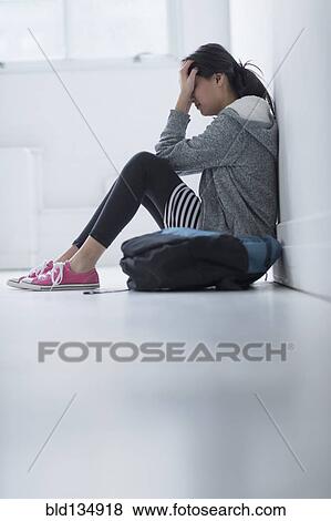 Mixed race teenage girl covering her face in school hallway View Large Photo Image Stock Photo - Mixed race teenage girl covering her face in school hallway. Fotosearch
