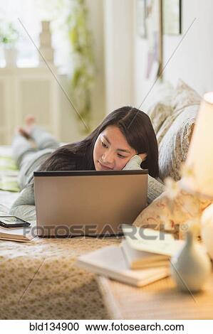 Mixed race teenage girl doing homework on bed View Large Photo Image Stock Image - Mixed race teenage girl doing homework on bed. Fotosearch