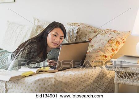 Mixed race teenage girl doing homework on bed View Large Photo Image Stock Image - Mixed race teenage girl doing homework on bed. Fotosearch