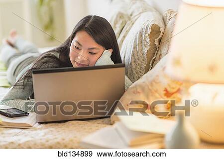 Mixed race teenage girl doing homework on bed View Large Photo Image Stock Photo - Mixed race teenage girl doing homework on bed. Fotosearch