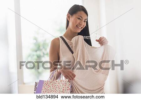 Picture - Mixed race teenage girl shopping in store. Fotosearch