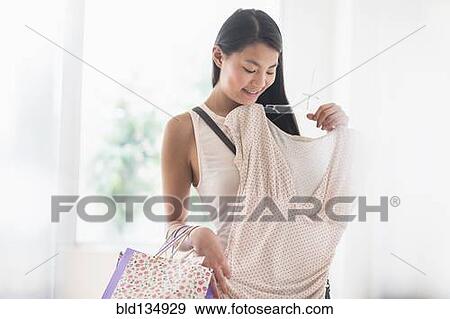 Mixed race teenage girl shopping in store View Large Photo Image Stock Photo - Mixed race teenage girl shopping in store. Fotosearch