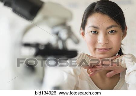 Mixed race teenage girl smiling in science lab View Large Photo Image Stock Photograph - Mixed race teenage girl smiling in science lab. Fotosearch