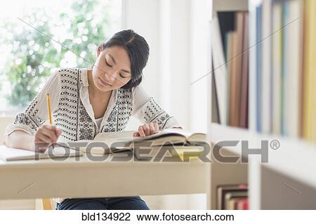 Mixed race teenage girl studying in library View Large Photo Image Stock Image - Mixed race teenage girl studying in library. Fotosearch