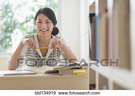 Mixed race teenage girl studying in library View Large Photo Image Stock Photo - Mixed race teenage girl studying in library. Fotosearch