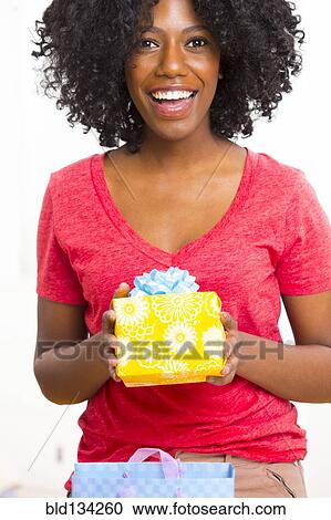 Mixed race woman holding birthday present View Large Photo Image Stock Image - Mixed race woman holding birthday present. Fotosearch