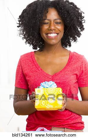 Mixed race woman holding birthday present View Large Photo Image Stock Image - Mixed race woman holding birthday present. Fotosearch