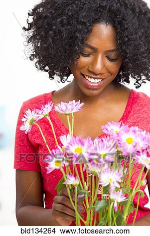 Mixed race woman holding bouquet of flowers View Large Photo Image Picture - Mixed race woman holding bouquet of flowers. Fotosearch
