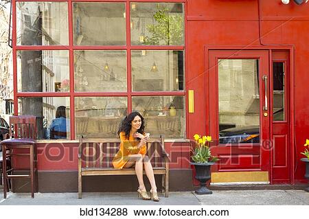 Mixed race woman on cell phone at sidewalk cafe View Large Photo Image Stock Photo - Mixed race woman on cell phone at sidewalk cafe. Fotosearch
