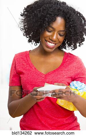 Mixed race woman reading birthday card View Large Photo Image Stock Image - Mixed race woman reading birthday card. Fotosearch
