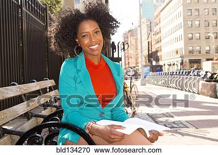 Mixed race woman reading on city bench View Large Photo Image Stock Image - Mixed race woman reading on city bench. Fotosearch