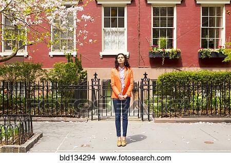 Mixed race woman standing on city sidewalk View Large Photo Image Picture - Mixed race woman standing on city sidewalk. Fotosearch