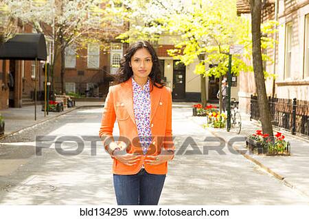 Stock Photography - Mixed race woman standing on city street. Fotosearch
