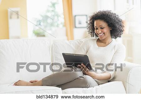 Mixed race woman using digital tablet View Large Photo Image Stock Photo - Mixed race woman using digital tablet. Fotosearch