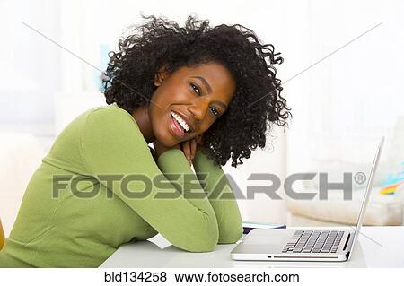 Mixed race woman using laptop at desk View Large Photo Image Stock Photo - Mixed race woman using laptop at desk. Fotosearch