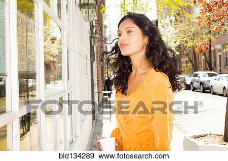 Mixed race woman window shopping on city sidewalk View Large Photo Image Stock Photo - Mixed race woman window shopping on city sidewalk. Fotosearch