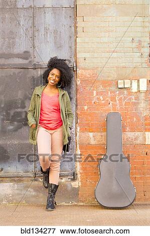 Mixed race woman with guitar case on city sidewalk View Large Photo Image Stock Photo - Mixed race woman with guitar case on city sidewalk. Fotosearch