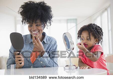 Stock Photo - Mother and daughter applying makeup. Fotosearch