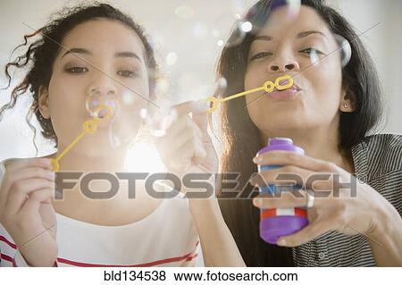 Mother and daughter blowing bubbles together View Large Photo Image Stock Photo - Mother and daughter blowing bubbles together. Fotosearch