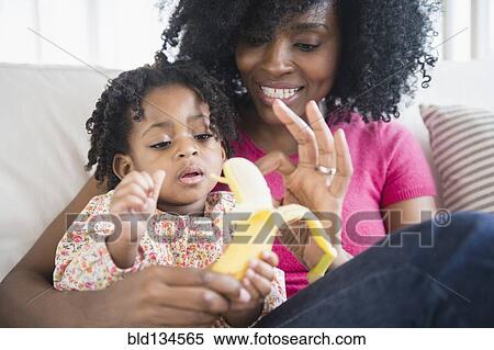 Mother and daughter eating banana View Large Photo Image Stock Photography - Mother and daughter eating banana. Fotosearch