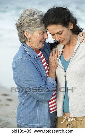 Mother and daughter hugging on beach View Large Photo Image Stock Image - Mother and daughter hugging on beach. Fotosearch