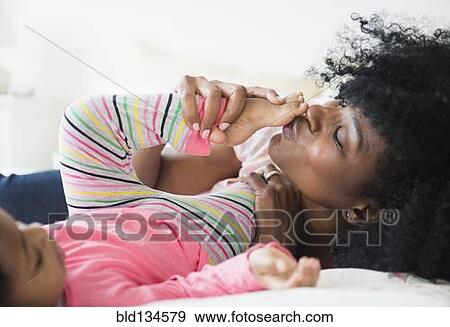 Mother and daughter playing on bed View Large Photo Image Stock Photo - Mother and daughter playing on bed. Fotosearch
