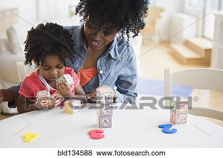 Stock Photo - Mother and daughter playing with wooden blocks. Fotosearch