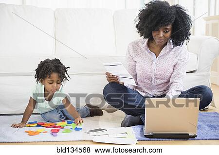 Mother and daughter relaxing in living room View Large Photo Image Stock Photo - Mother and daughter relaxing in living room. Fotosearch