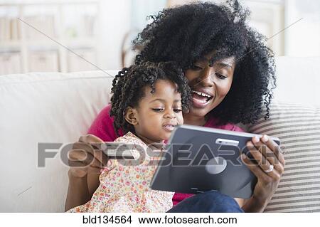 Picture - Mother and daughter shopping on tablet computer. Fotosearch