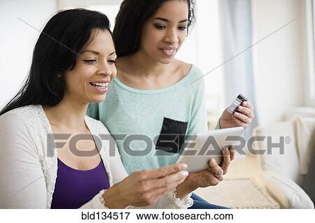 Mother and daughter using tablet computer together View Large Photo Image Stock Photo - Mother and daughter using tablet computer together. Fotosearch