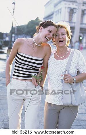 Mother and daughter walking on city street View Large Photo Image Stock Photography - Mother and daughter walking on city street. Fotosearch
