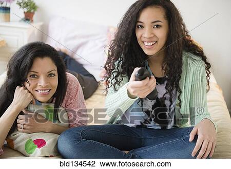 Mother and daughter watching television on bed View Large Photo Image Stock Image - Mother and daughter watching television on bed. Fotosearch