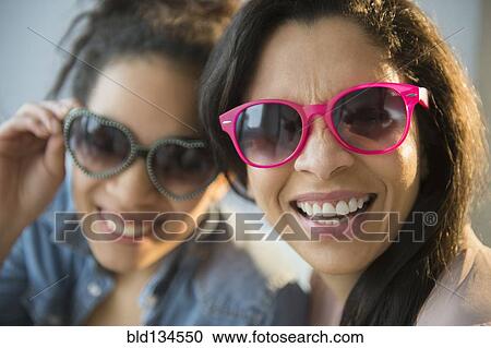 Stock Image - Mother and daughter wearing novelty sunglasses. Fotosearch