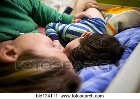 Stock Image - Mother and son napping in bed. Fotosearch