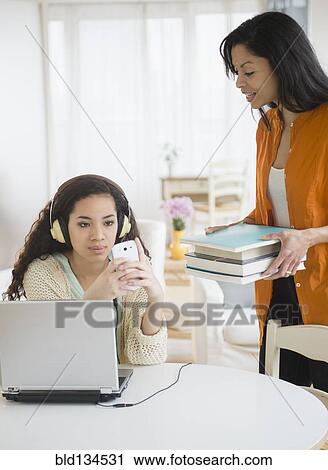 Mother bringing homework to busy daughter View Large Photo Image Stock Image - Mother bringing homework to busy daughter. Fotosearch