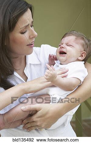 Stock Image - Mother comforting crying baby. Fotosearch