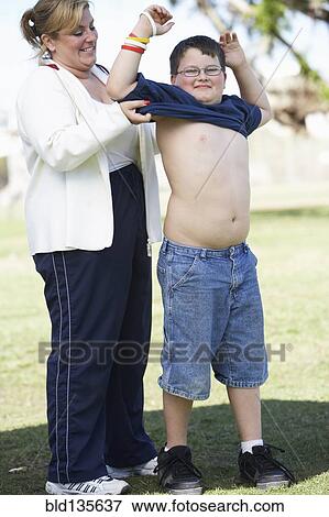 Mother helping son put on t-shirt View Large Photo Image Stock Photo - Mother helping son put on t-shirt. Fotosearch