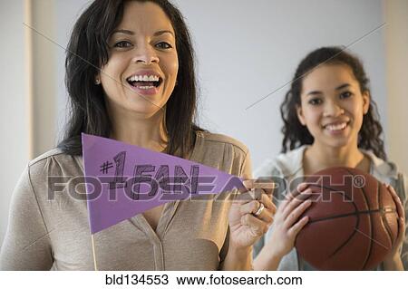 Stock Image - Mother holding fan flag for athlete daughter. Fotosearch