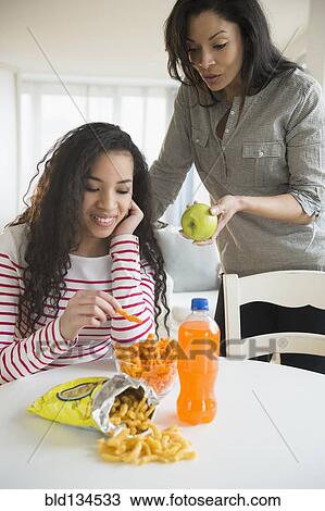 Mother offering daughter healthy snack View Large Photo Image Stock Image - Mother offering daughter healthy snack. Fotosearch