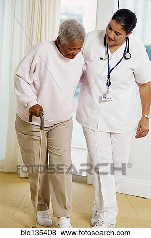 Nurse helping patient use cane View Large Photo Image Stock Photo - Nurse helping patient use cane. Fotosearch