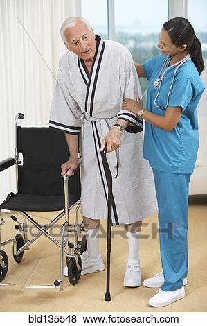 Nurse helping Senior patient use cane View Large Photo Image Stock Photo - Nurse helping Senior patient use cane. Fotosearch