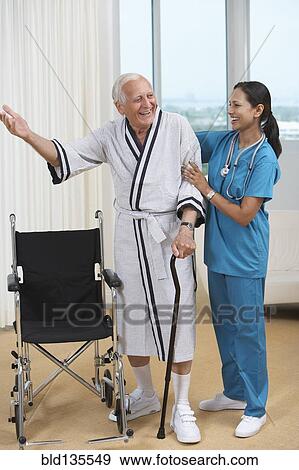 Nurse helping Senior patient use cane View Large Photo Image Stock Photo - Nurse helping Senior patient use cane. Fotosearch
