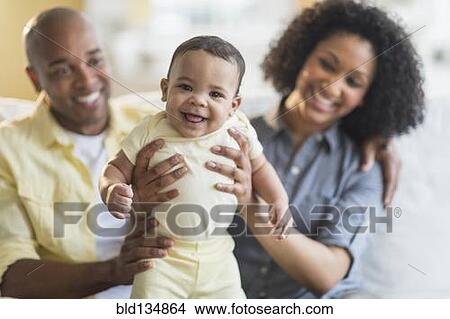 Parents playing with baby in living room View Large Photo Image Picture - Parents playing with baby in living room. Fotosearch