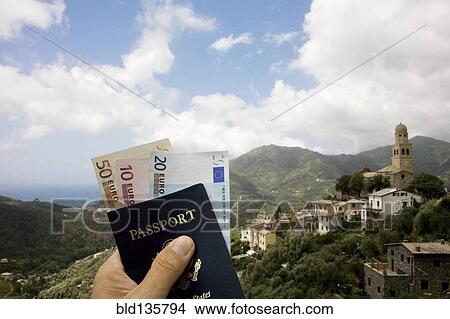 Passport and Euros overlooking rural landscape, Italy, Linguria, Italy View Large Photo Image Picture - Passport and Euros overlooking rural landscape, Italy, Linguria, Italy. Fotosearch