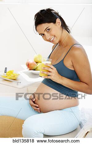 Pregnant Hispanic woman drinking fruit juice View Large Photo Image Stock Photo - Pregnant Hispanic woman drinking fruit juice. Fotosearch