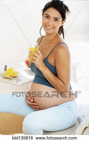 Pregnant Hispanic woman drinking fruit juice View Large Photo Image Stock Photograph - Pregnant Hispanic woman drinking fruit juice. Fotosearch