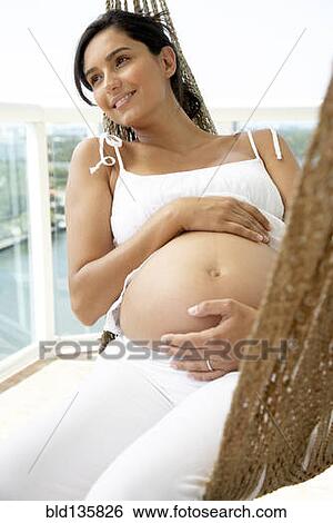 Pregnant Hispanic woman holding her belly View Large Photo Image Stock Photograph - Pregnant Hispanic woman holding her belly. Fotosearch
